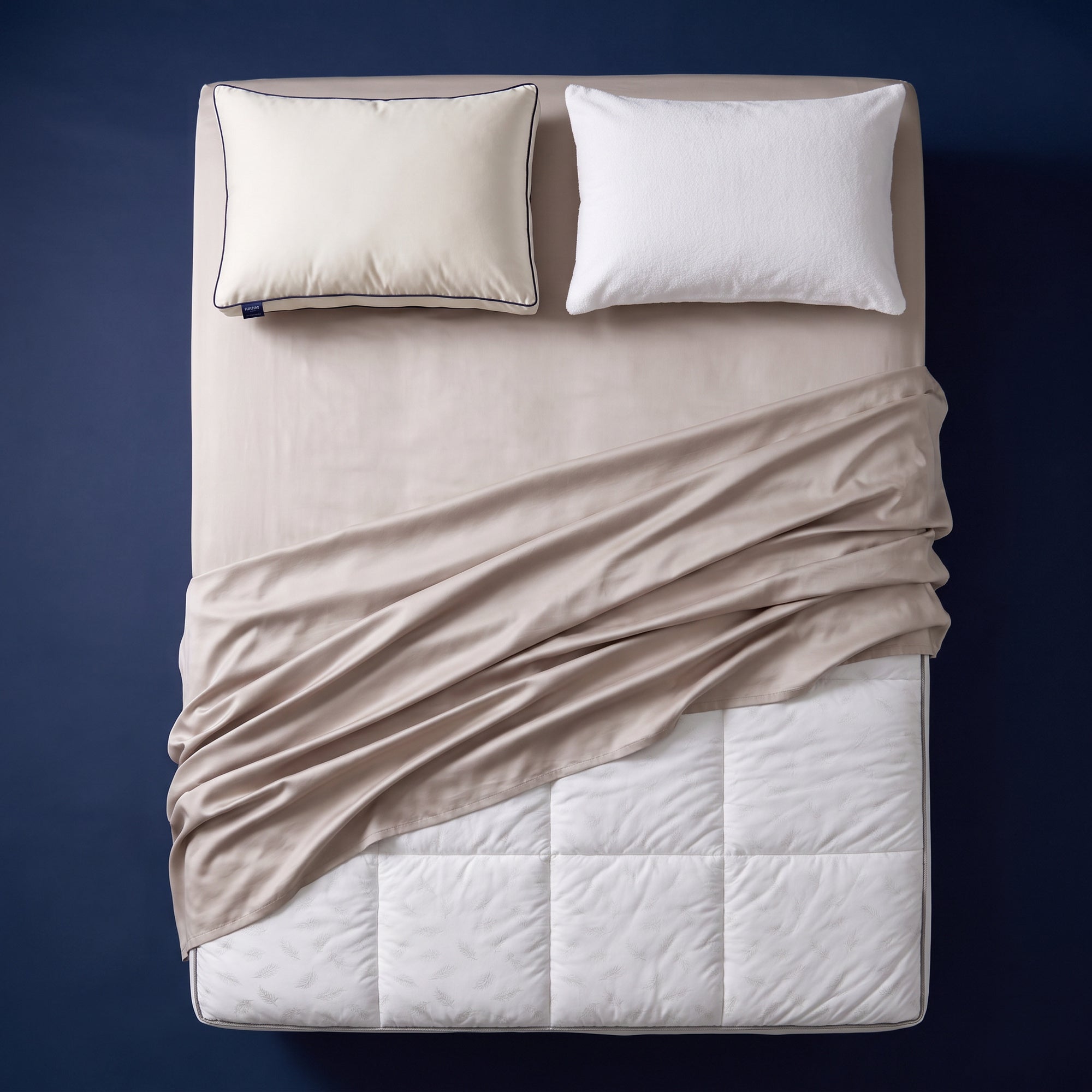 The Complete Sleep System - bamboo sateen sheet set, quilted mattress topper, support pillow and pillow protector arranged on a made bed, viewed from above